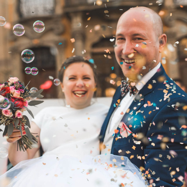 Brautpaar im Konfettiregen bei Standesamt Trauung in Schwäbisch Hall mit Seifenblasen und lachenden Gesichtern bei Winterhochzeit