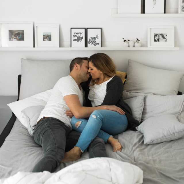 Paar kuschelt im Bett während eines Homestory Shootings mit Fotograf und stylischer Einrichtung
