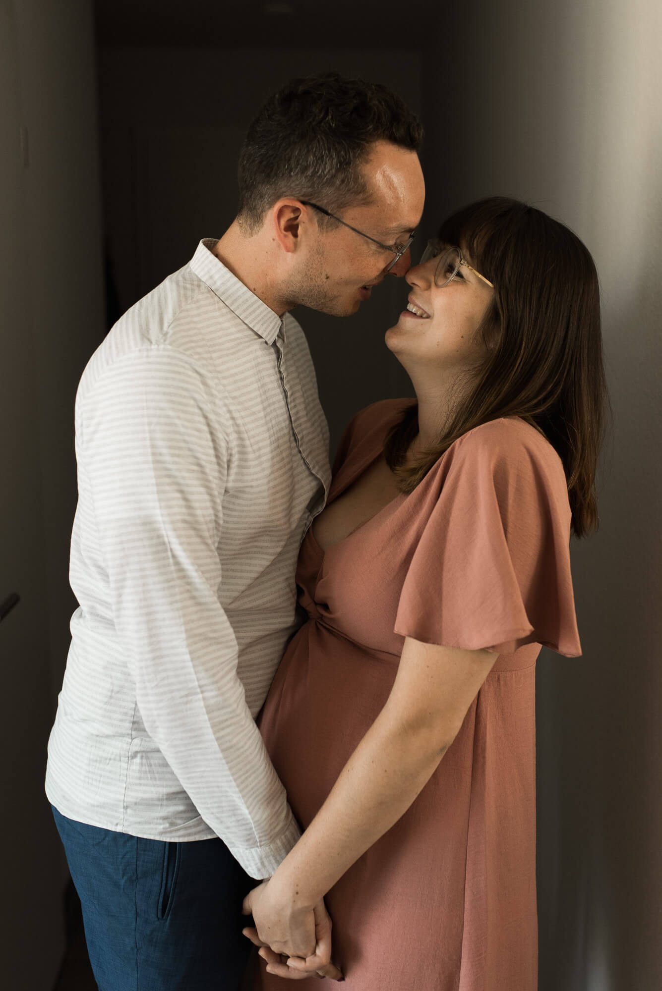 Babybauchshooting mit glücklichem Paar und Fotograf in eigener Wohnung als Homestory
