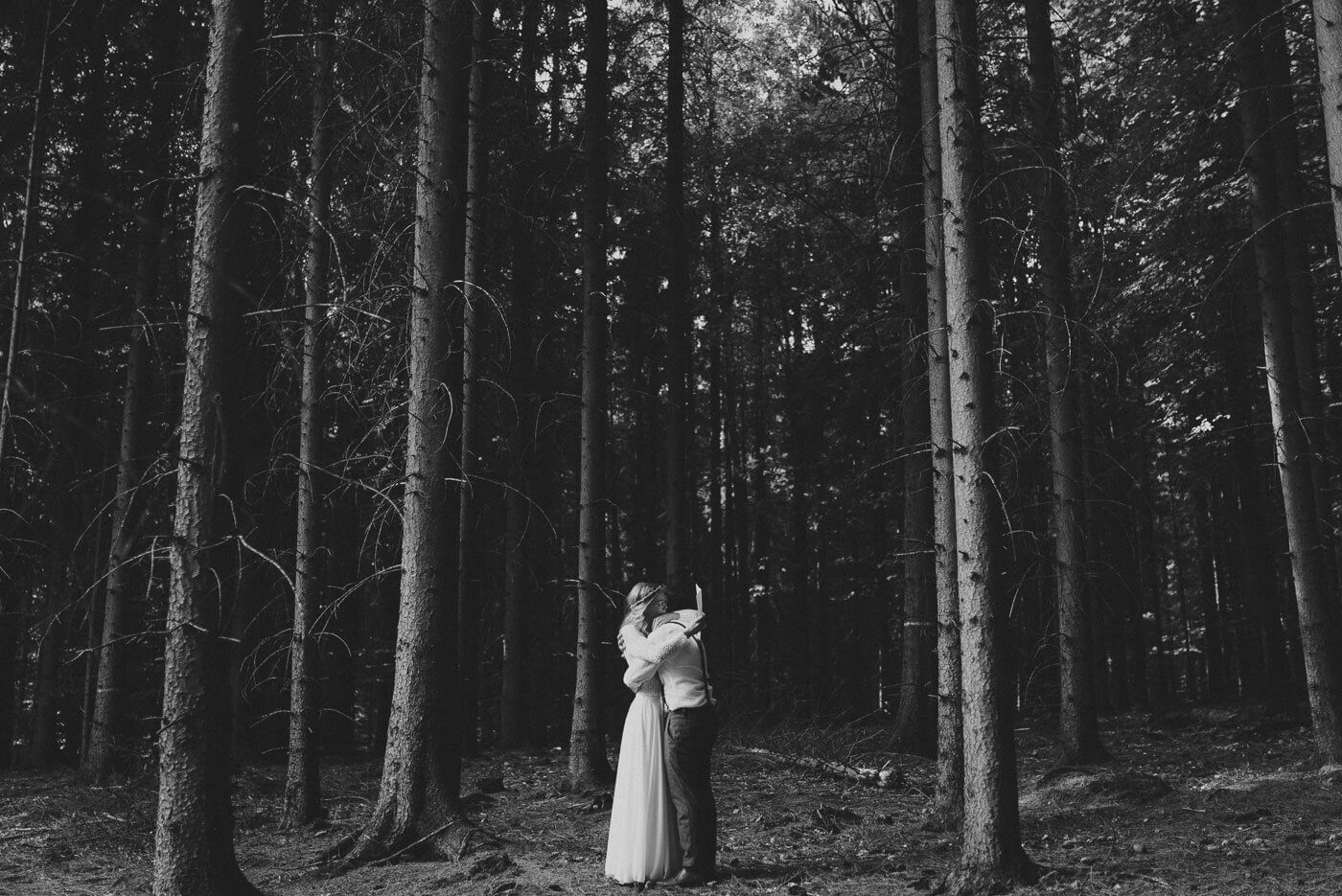 Brautpaar liest sich Trauversprechen alleine im Wald bei Forest Wedding vor und umarmt sich