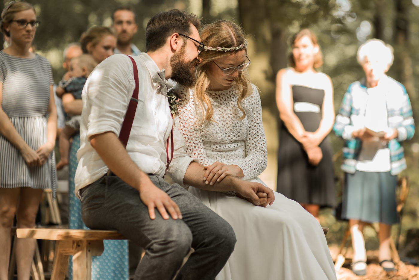 Brautpaar flüstert bei Trauung miteinander auf Teppich bei Forest Wedding