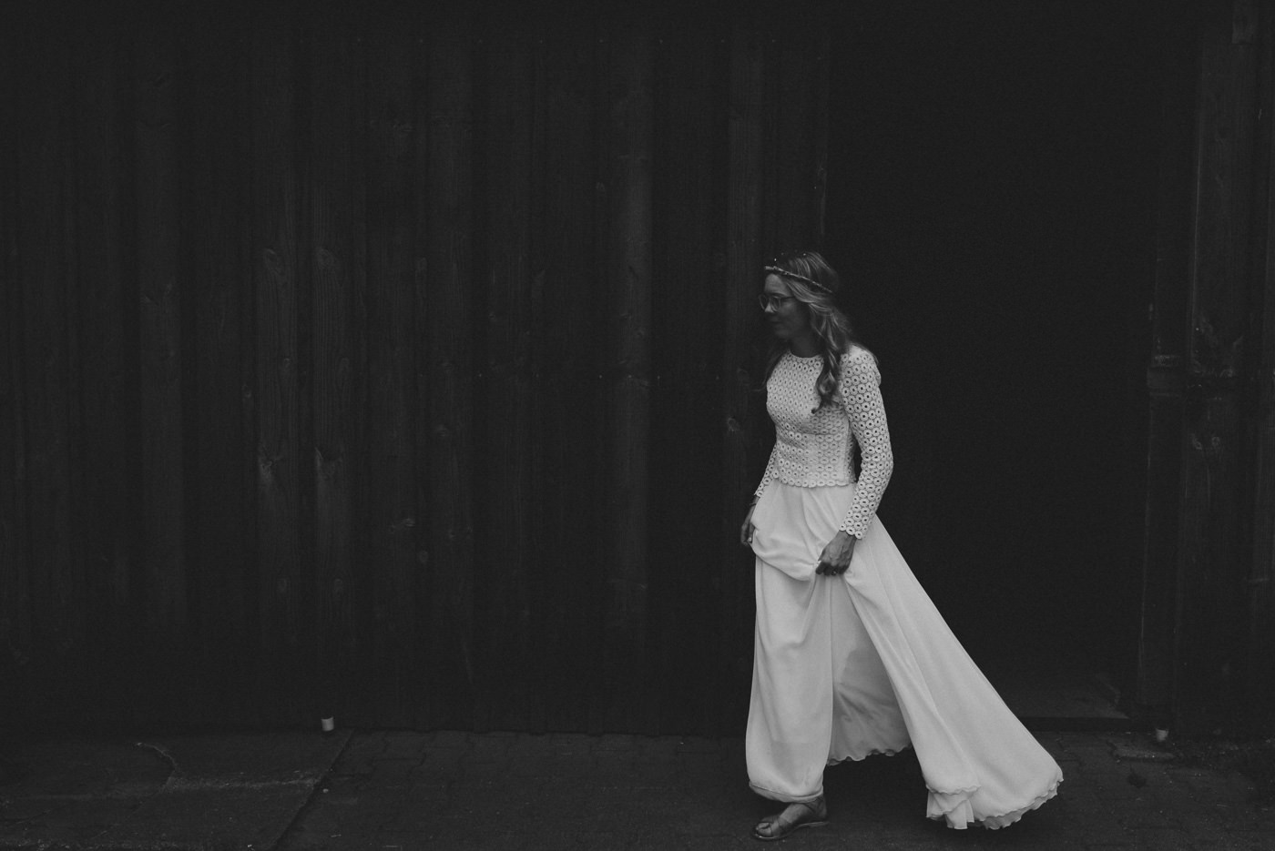 Bride walking with her wedding dress in the dark of a hut in the forest