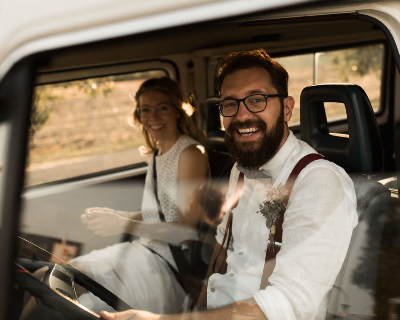 Camper Hochzeit mit glücklichen Brautpaar in VW Bully Hochzeitsauto und dieses Auto auch zur Übernachtung nutzen