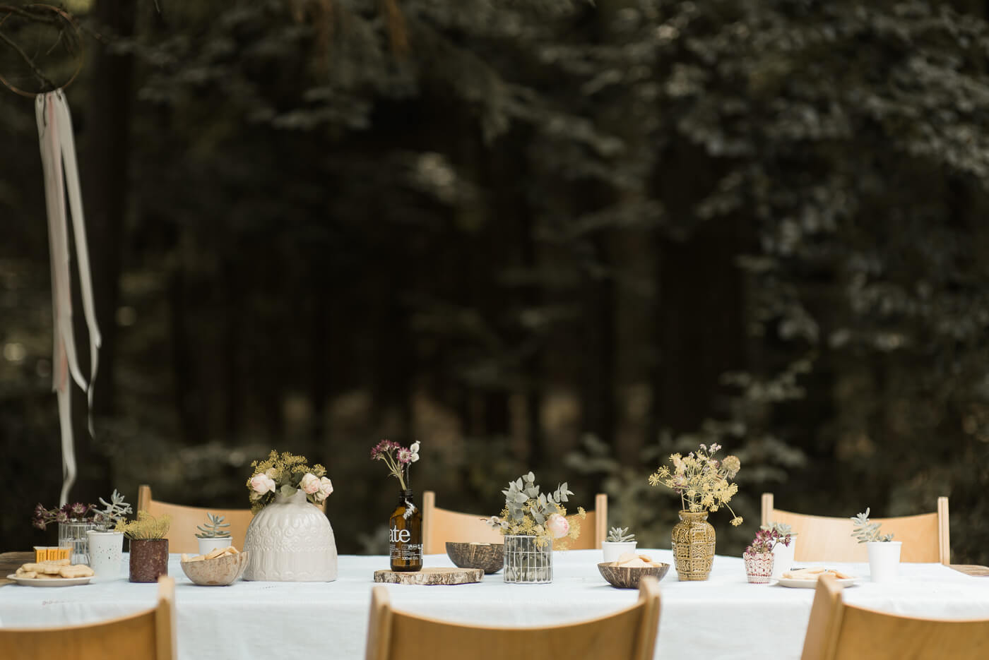 Tischdekoration mit Eukalyptus und Keksen bei Hochzeit in der Natur