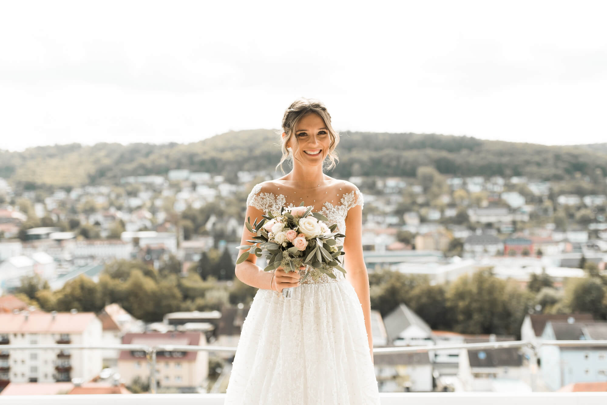 Braut mit Stadt Panorama im Hintergrund mit Brautstrauß Blumen von Grüner Garten Mosbach und einem Hochzeitskleid von Lorenzo Rossi