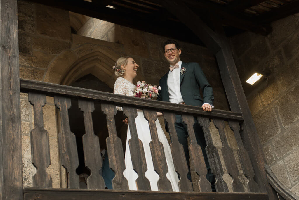 Brautpaar nach Trauung in Katharinenkapelle auf Balkon lacht gemeinsam 