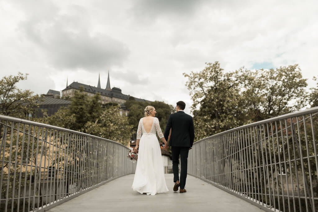 Brautpaar läuft über Brücke am Kongresszentrum in Bamberg