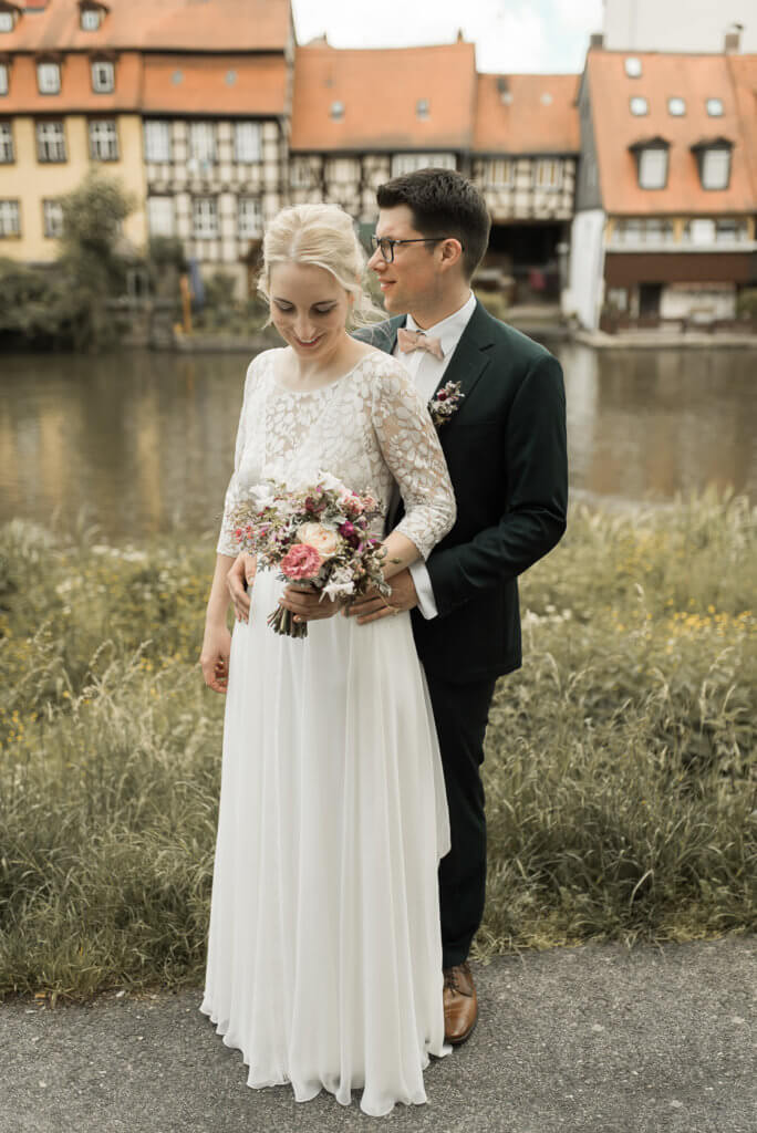 Brautpaar steht in Bamberg vor Klein Venedig an der Regnitz