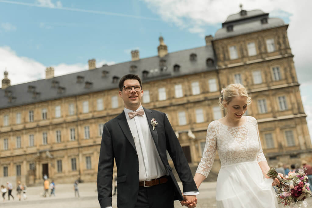 Brautpaar steht auf Domplatz vor der neuen Residenz in Bamberg bevor es in die Katharinenkapelle zur Hochzeit geht