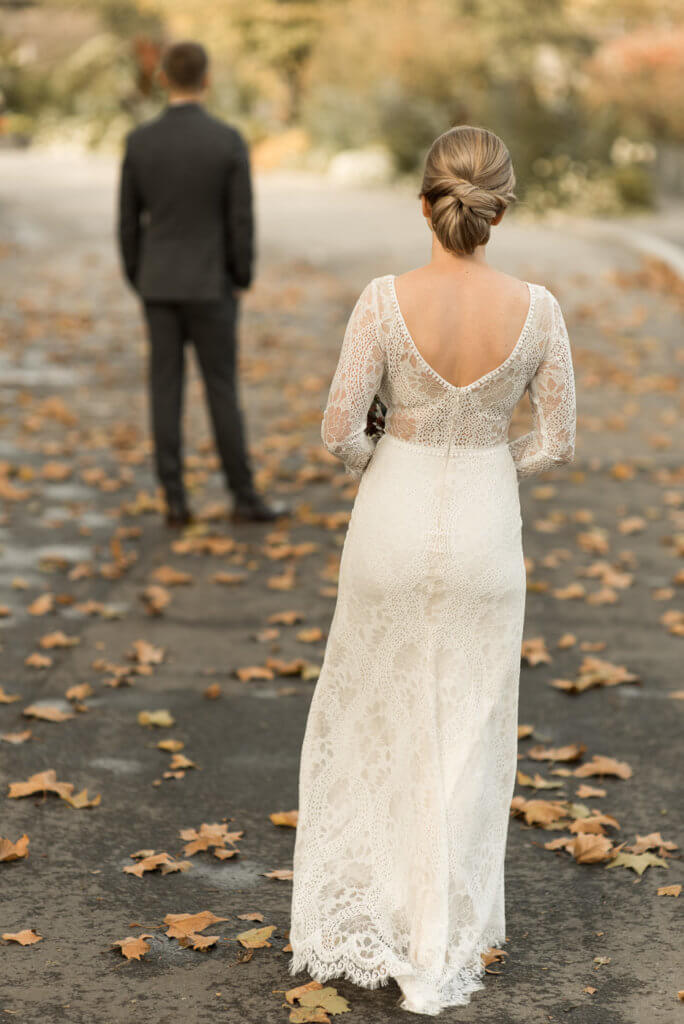 Braut läuft in Hochzeitskleid bei First Look auf Bräutigam zu