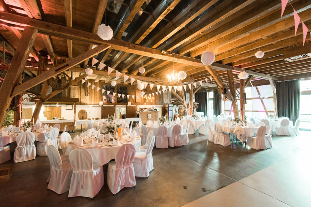 Hochzeitslocation in Schwäbisch Hall mit Scheune dekoriert mit Wimpelketten und Pom Pom für Vintage Boho Scheunenhochzeit