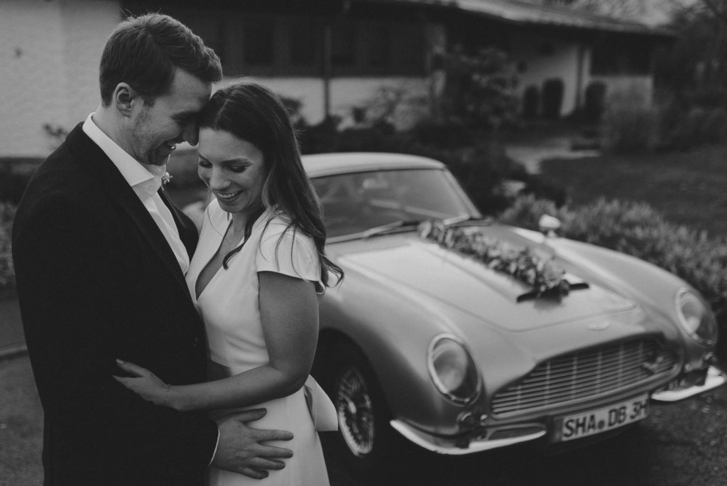 Aston Martin DB 5 James Bond 007 als Hochzeitsauto mit Brautpaar während Hochzeitsshooting