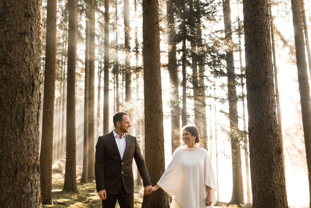 Brautpaar nach Hochzeit zum Shooting im Wald im Winter mit Sonne und mit Hochzeitsfotograf in Franken