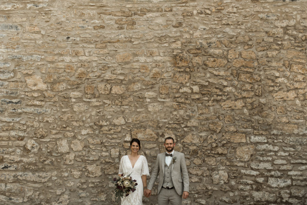 Brautpaar vor rustikaler Steinwand auf Boho Vintage Hochzeit bei Landgut Halsberg zwischen Stuttgart und Würzburg