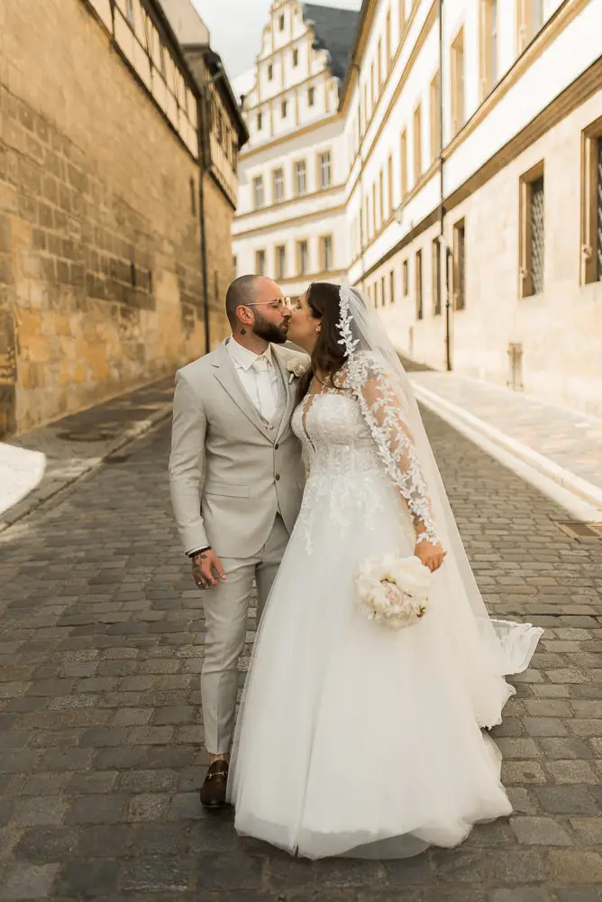 Hochzeit mit Kuss und Brautpaar Fotos in der Altstadt von Bamberg mit der Alten Hofhaltung in der Nähe der Katharinenkapelle